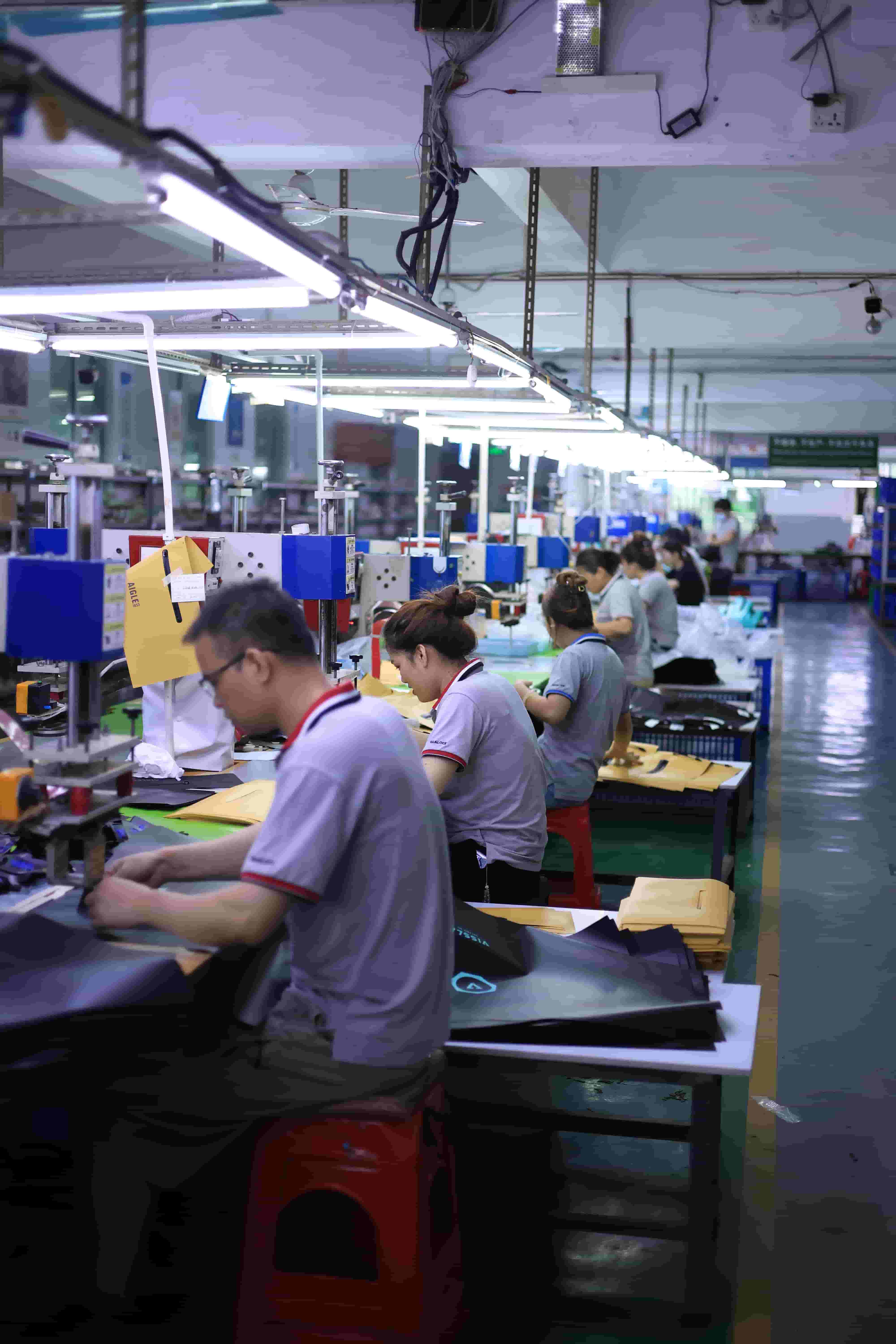 High-frequency RF welding stations on the Sealock waterproof bag factory floor with operators aligning TPU fabric